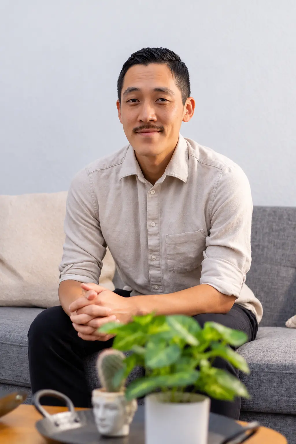 Chiwoo seated in a living room, smiling toward the camera